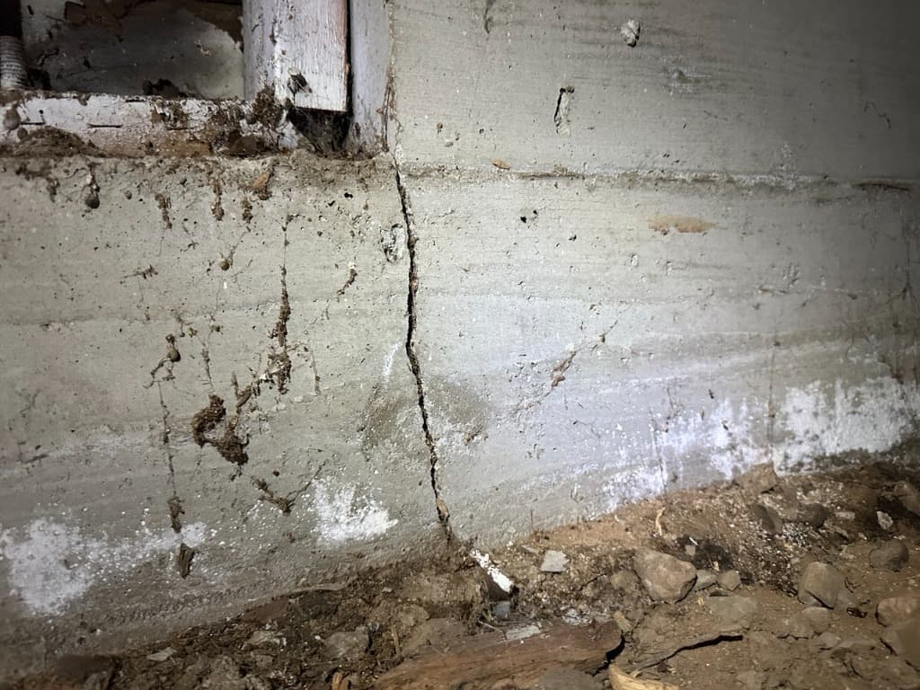 Extensive mineral leaching and moisture staining at base of unwaterproofed stem wall